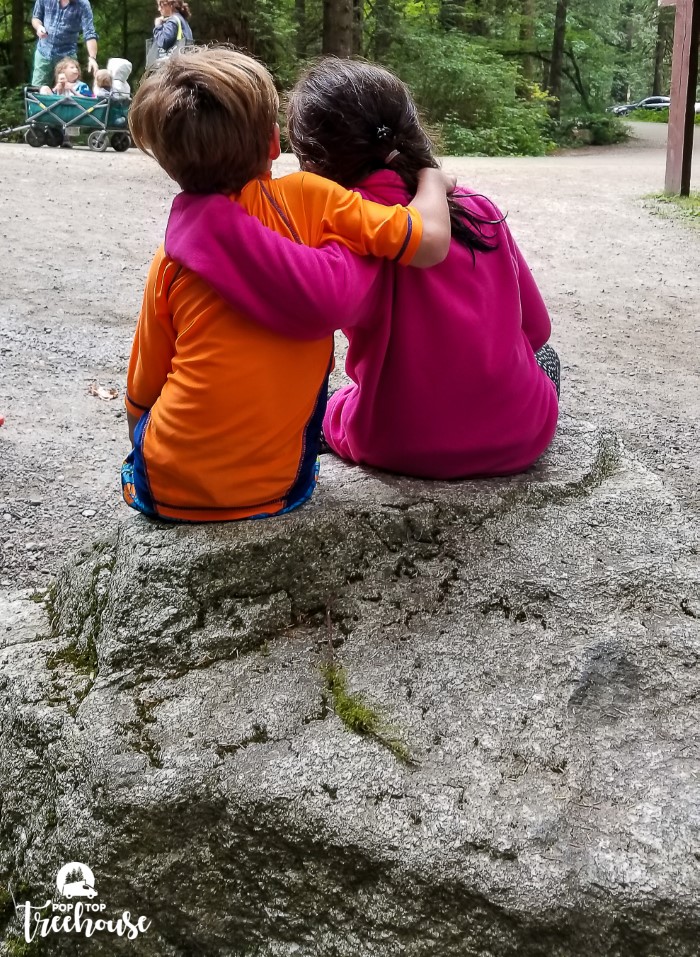 camping with kids, two kids hugging on a rock