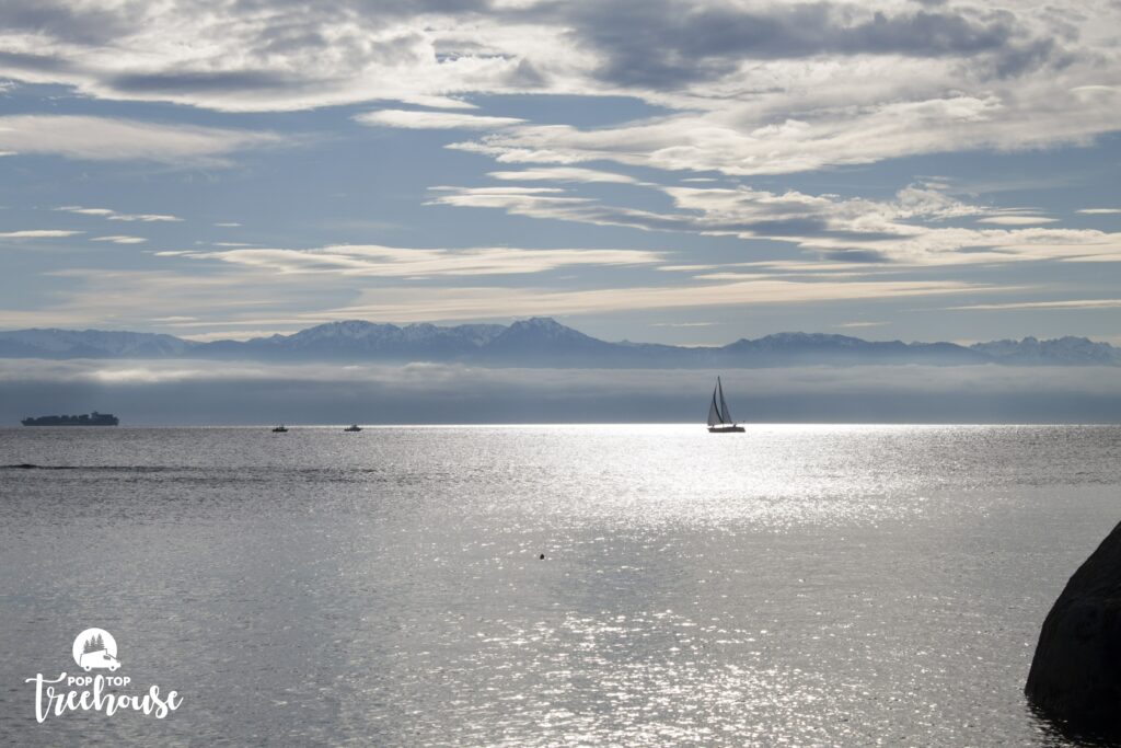 view of sail boat and ocean with mountains in background